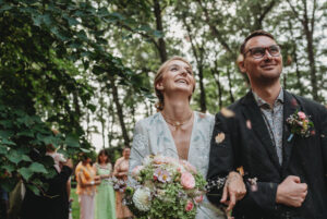 Nevěsta a ženich se smějí a prochází špalírem